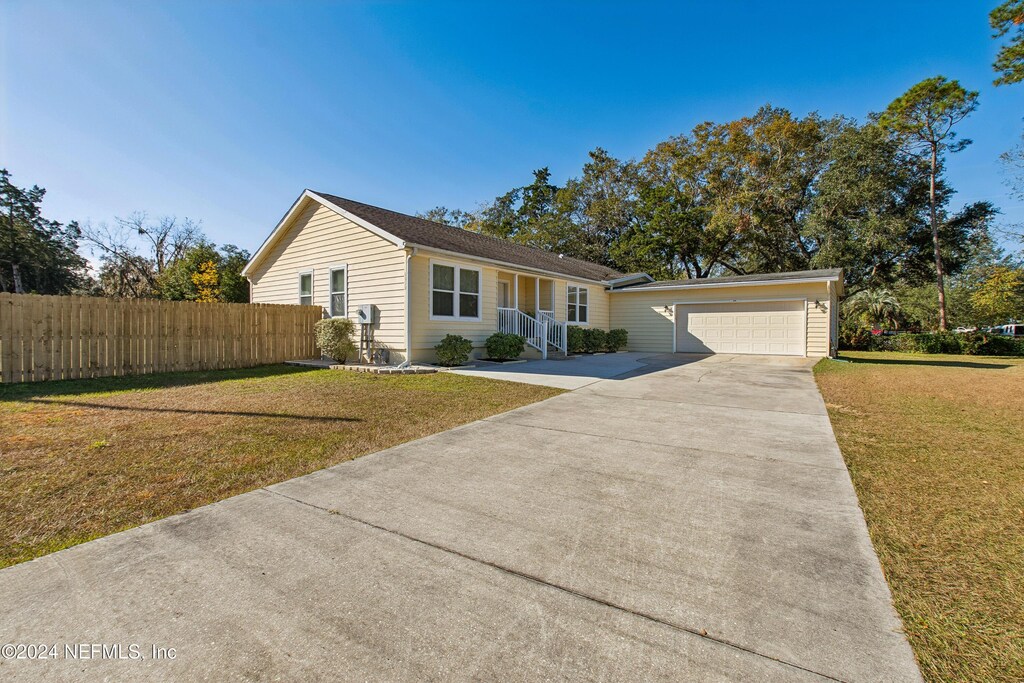 ranch-style house with a garage and a front lawn