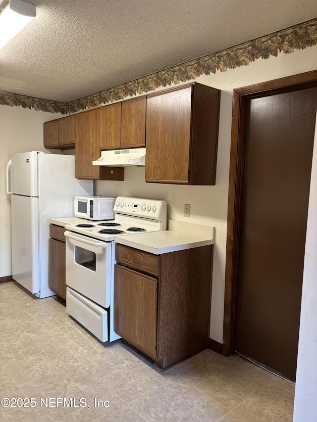 kitchen featuring white appliances and a textured ceiling