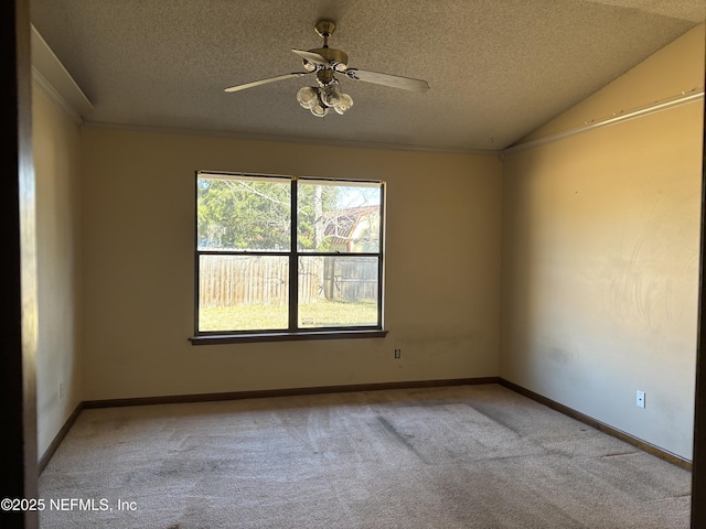 carpeted spare room with vaulted ceiling, ceiling fan, and a textured ceiling