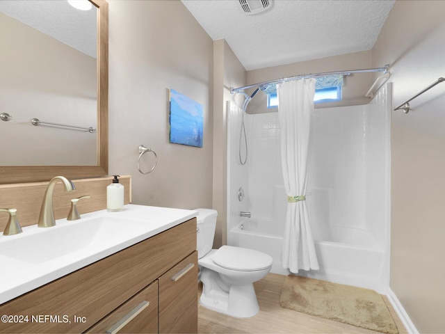 full bathroom featuring vanity, toilet, a textured ceiling, shower / tub combo with curtain, and wood-type flooring