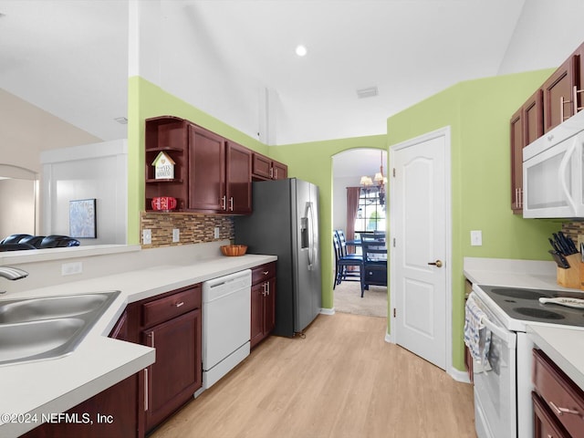 kitchen with decorative backsplash, white appliances, vaulted ceiling, sink, and light hardwood / wood-style flooring