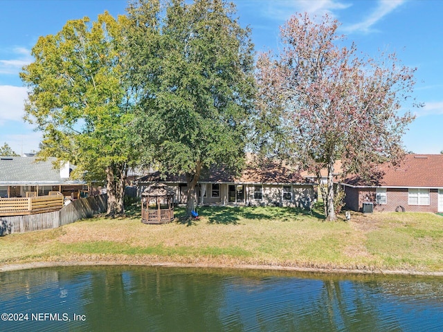 back of house featuring a yard and a water view