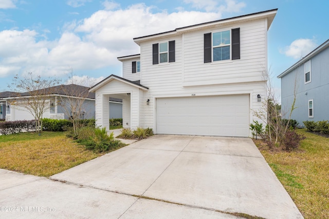 view of property with a front yard and a garage