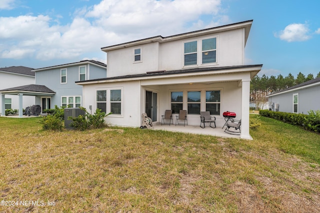 rear view of property with central AC unit and a yard