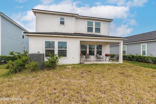 rear view of house featuring a lawn, a patio area, and central AC unit