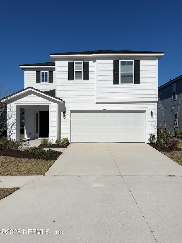 traditional home featuring concrete driveway and an attached garage