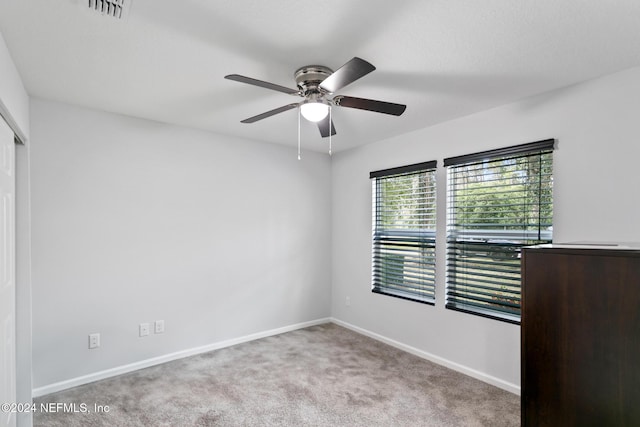 empty room featuring ceiling fan and carpet floors