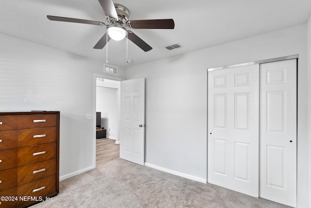 unfurnished bedroom with light carpet, a closet, and ceiling fan