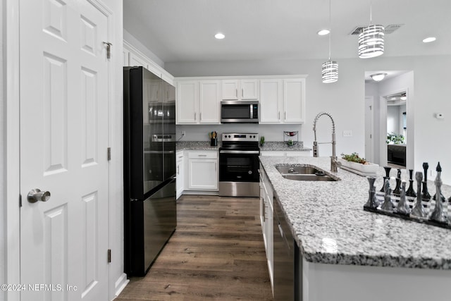 kitchen with appliances with stainless steel finishes, dark hardwood / wood-style flooring, sink, decorative light fixtures, and white cabinetry