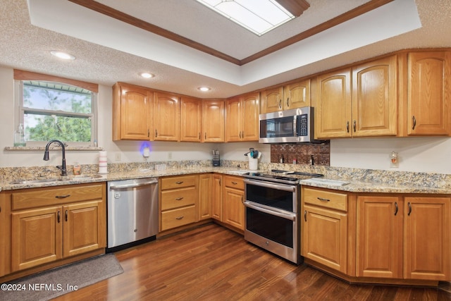 kitchen featuring appliances with stainless steel finishes, light stone countertops, crown molding, and sink