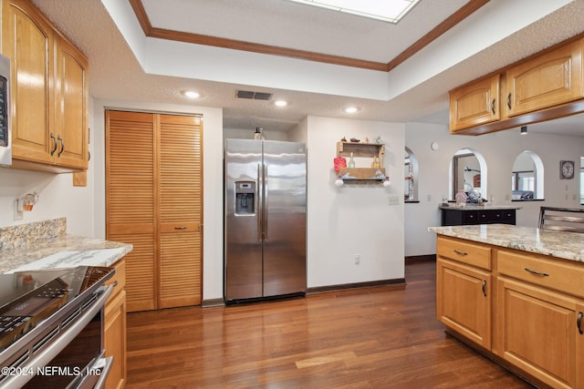 kitchen featuring stainless steel appliances, a raised ceiling, ornamental molding, and light stone countertops