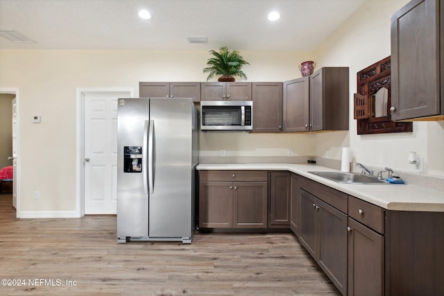 kitchen featuring dark brown cabinetry, appliances with stainless steel finishes, light hardwood / wood-style floors, and sink