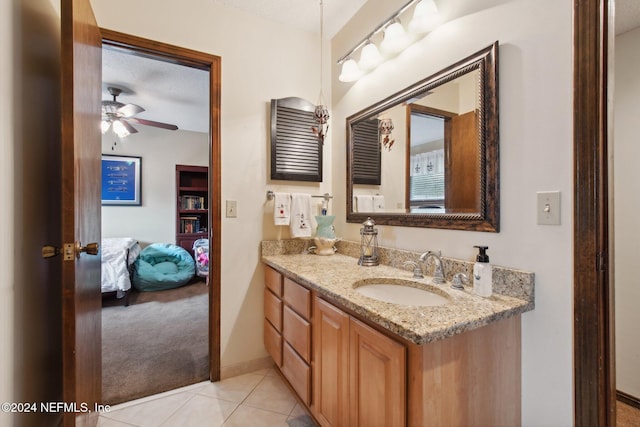 bathroom with tile patterned flooring, ceiling fan, a textured ceiling, and vanity