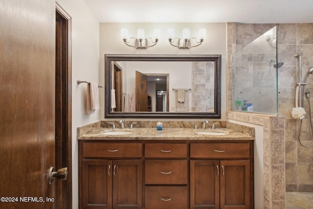 bathroom with tiled shower and vanity