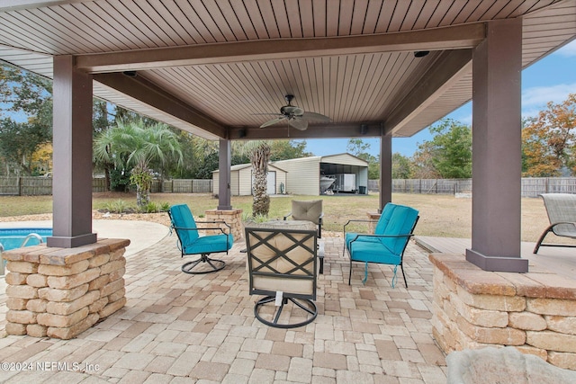 view of patio with ceiling fan and a shed