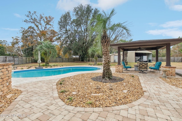 view of pool with an outdoor fire pit, a patio, and a shed