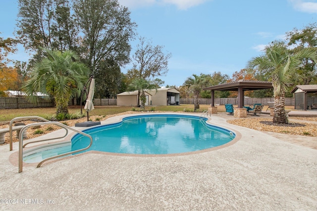 view of pool featuring a gazebo, a patio, and a shed