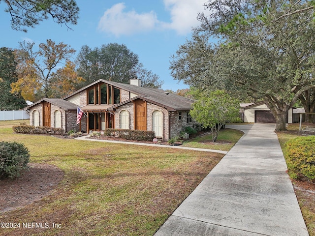 view of front of house with a front lawn, a garage, and an outbuilding