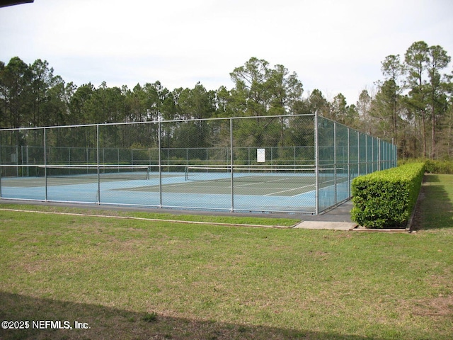 view of tennis court with a yard