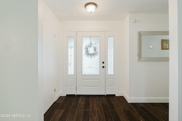 entryway featuring a textured ceiling and dark wood-type flooring