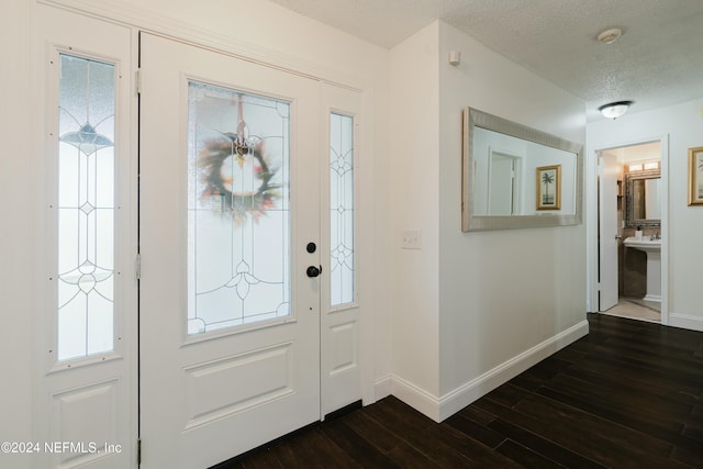 foyer with dark hardwood / wood-style flooring and a textured ceiling