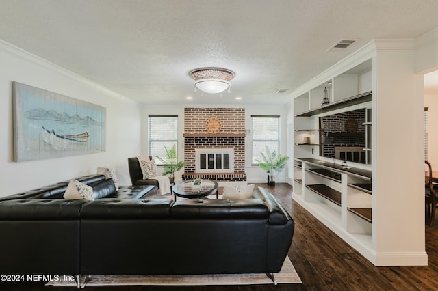 living room featuring a fireplace, a textured ceiling, dark hardwood / wood-style flooring, and crown molding