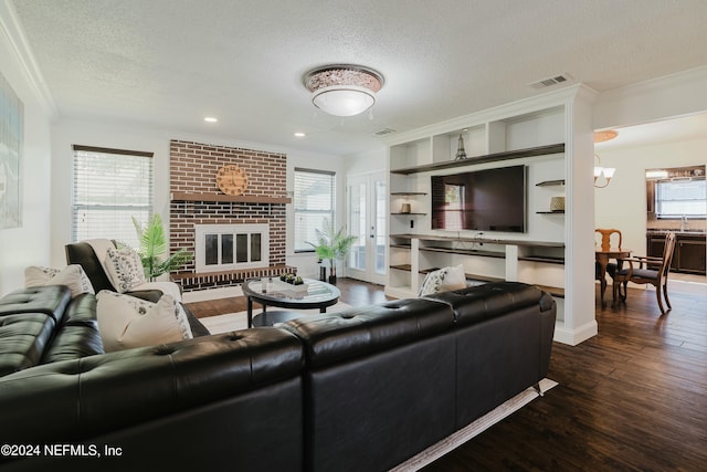 living room with a wealth of natural light, dark wood-type flooring, and a textured ceiling