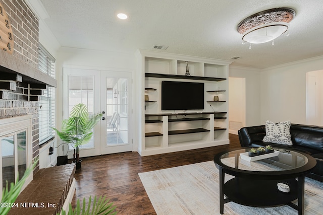 living room featuring dark hardwood / wood-style floors, a textured ceiling, a wealth of natural light, and french doors