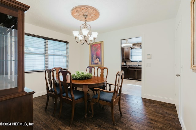 dining space with dark hardwood / wood-style floors, plenty of natural light, a notable chandelier, and sink