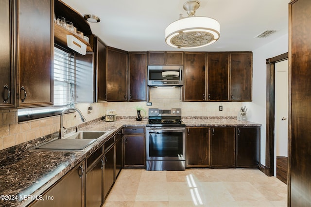 kitchen featuring dark brown cabinetry, stainless steel appliances, tasteful backsplash, and sink