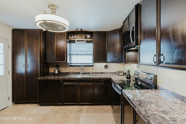 kitchen featuring black electric range oven, dark stone countertops, sink, and tasteful backsplash