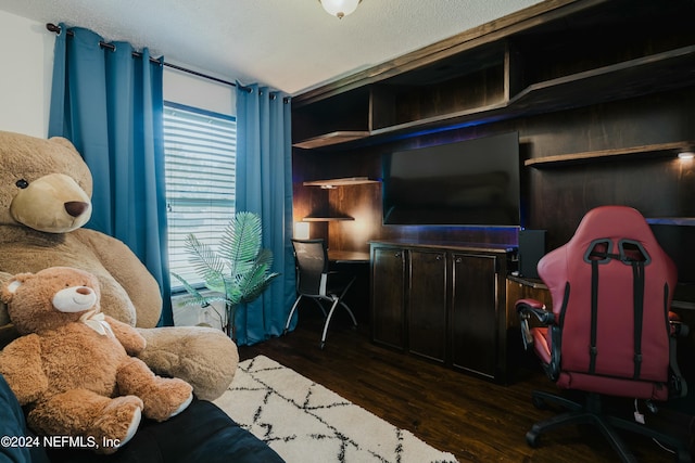 bedroom with a textured ceiling and dark wood-type flooring