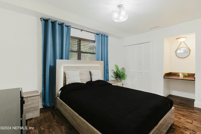 bedroom with dark hardwood / wood-style floors and a closet