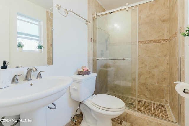 bathroom with tile patterned floors, toilet, walk in shower, and sink