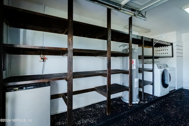 storage room with washer and clothes dryer and water heater