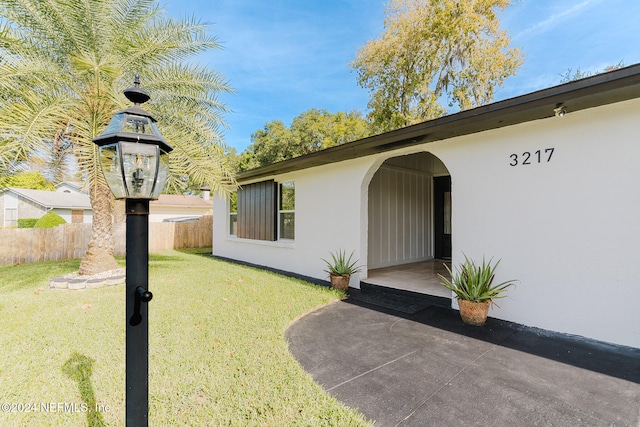 view of exterior entry with a yard