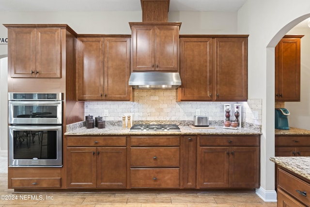 5321 Muskogean St, Saint Augustine, FL 32092 - kitchen featuring stainless steel appliances, extractor fan, arched walkways, and decorative backsplash