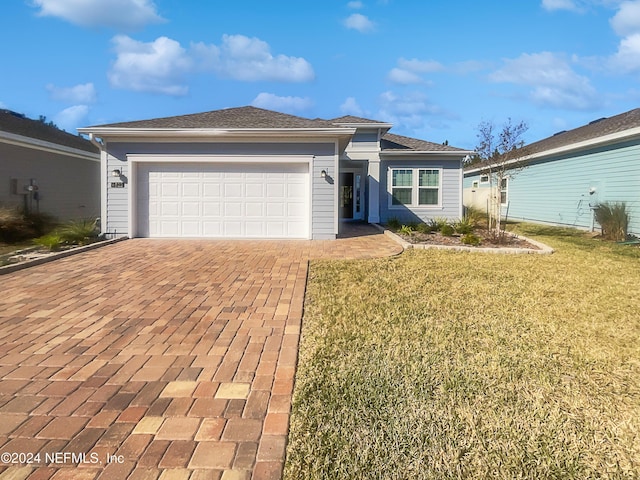 view of front of property with a front yard and a garage