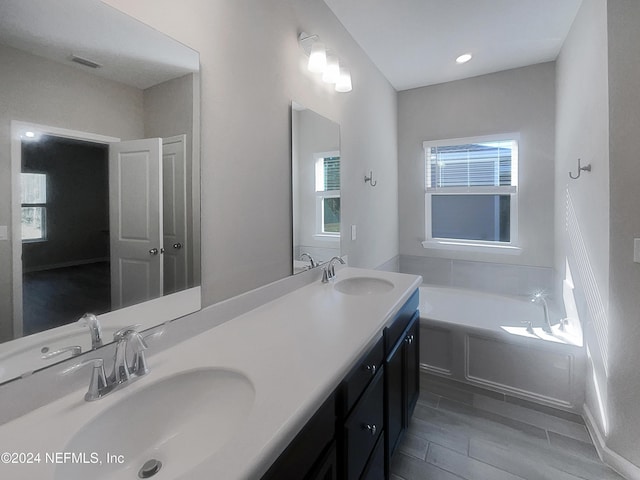 bathroom with a bathing tub, vanity, and wood-type flooring