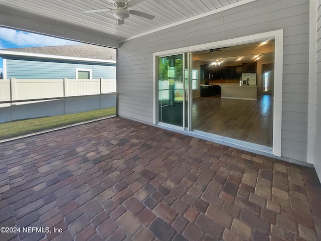 unfurnished sunroom with ceiling fan