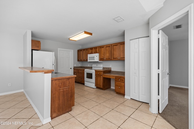 kitchen featuring kitchen peninsula, white appliances, and light tile patterned flooring