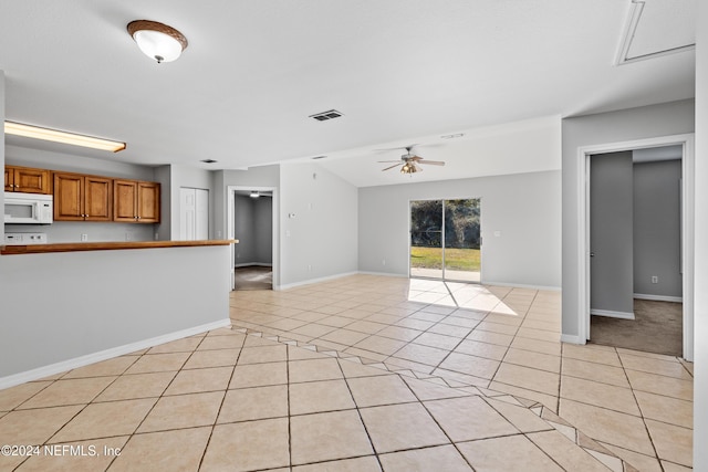 unfurnished living room featuring ceiling fan and light tile patterned floors