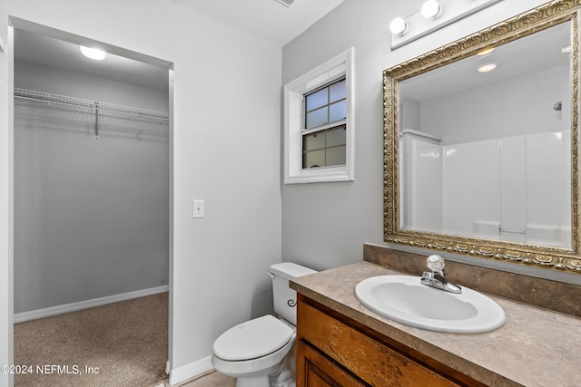 bathroom featuring a shower, vanity, and toilet