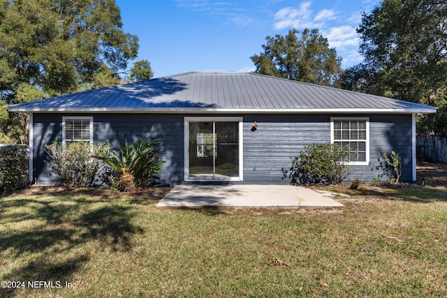 back of house featuring a lawn and a patio area