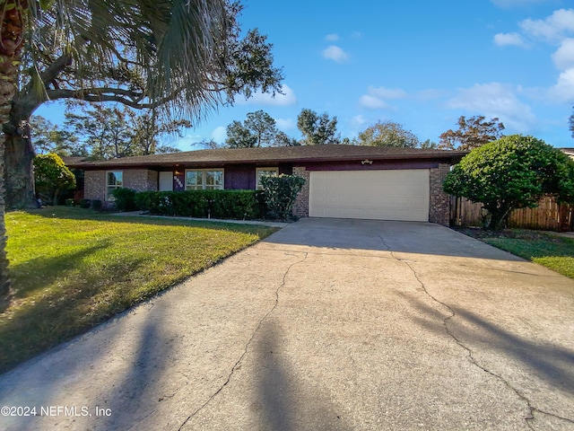 single story home with a garage and a front lawn