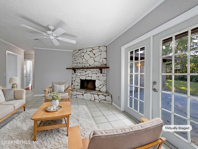 tiled living room featuring a fireplace, a textured ceiling, ceiling fan, and crown molding