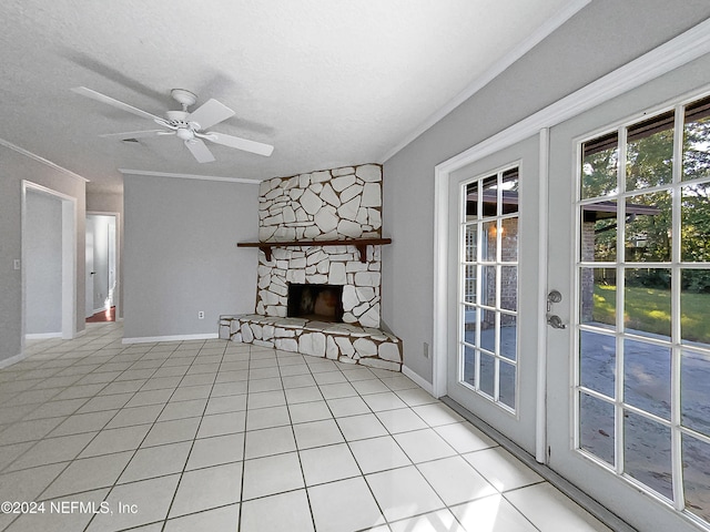 unfurnished living room featuring ceiling fan, light tile patterned flooring, and a stone fireplace