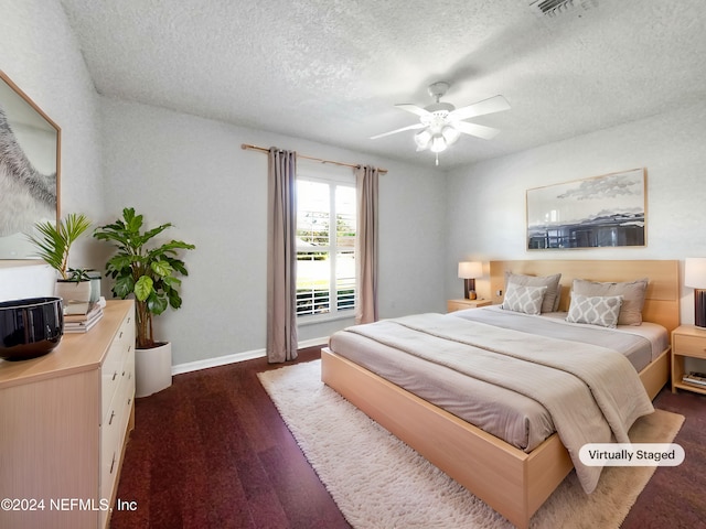 bedroom with dark hardwood / wood-style floors, ceiling fan, and a textured ceiling