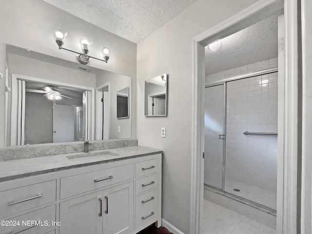 bathroom with ceiling fan, a shower with shower door, and a textured ceiling