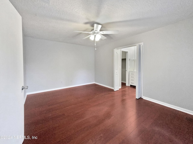 unfurnished room featuring a textured ceiling, ceiling fan, and dark wood-type flooring